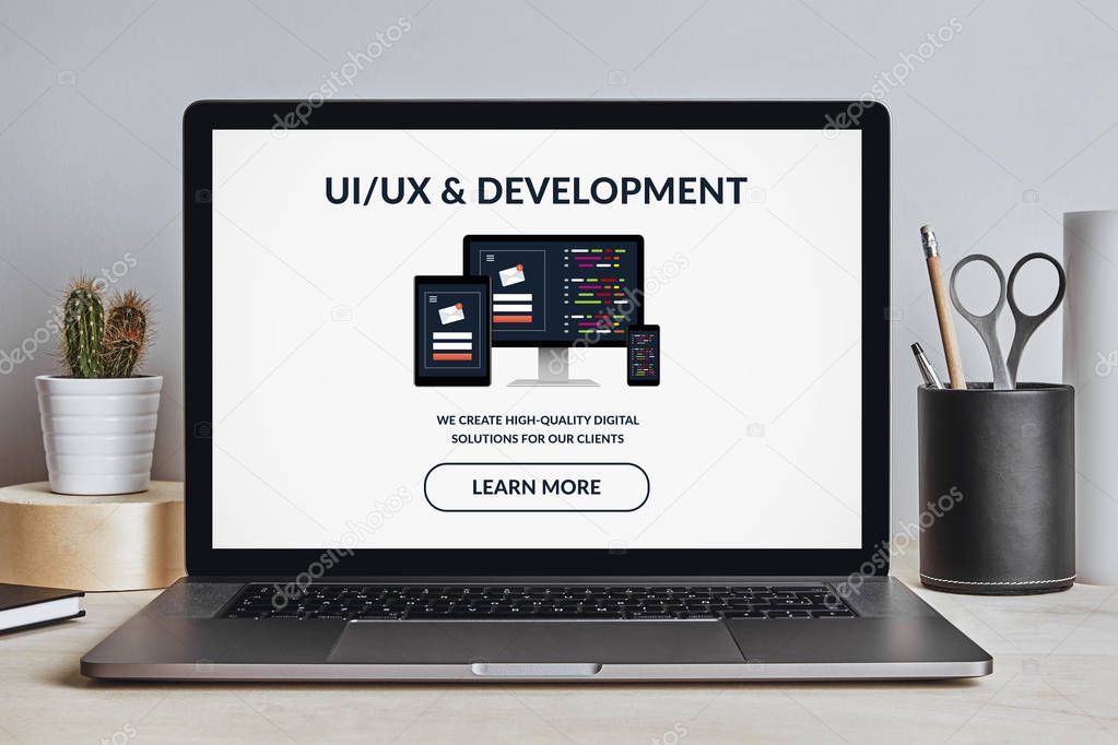 UI/UX design and development concept on laptop screen on modern desk