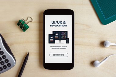 Ahşap masa üzerinde akıllı telefon ekranında UI/Ux tasarım ve geliştirme kavramı