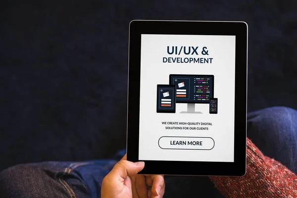 Hands holding tablet with UI / UX design and development concept on screen — стоковое фото
