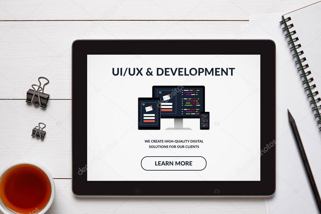 UI/UX design and development concept on tablet screen with office objects