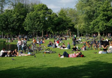 Vondelpark'ta güneşli bir günün tadını çıkaran insanlar