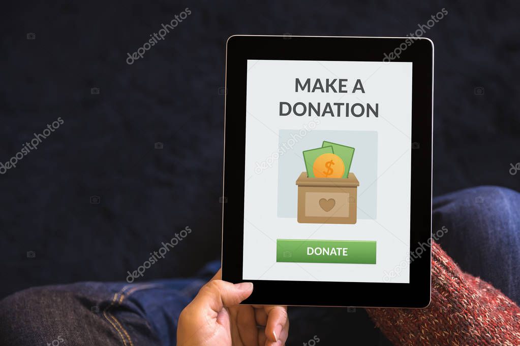 Hands holding tablet with donation concept on screen