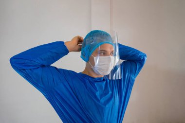 Erkek cerrah hastanede yüzünü maskeyle örtüyor. Tıbbi konsept