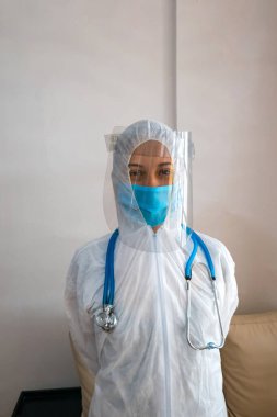 Biyolojik koruyucu kıyafetli ve steteskoplu genç bir doktor. Salgın kavramı