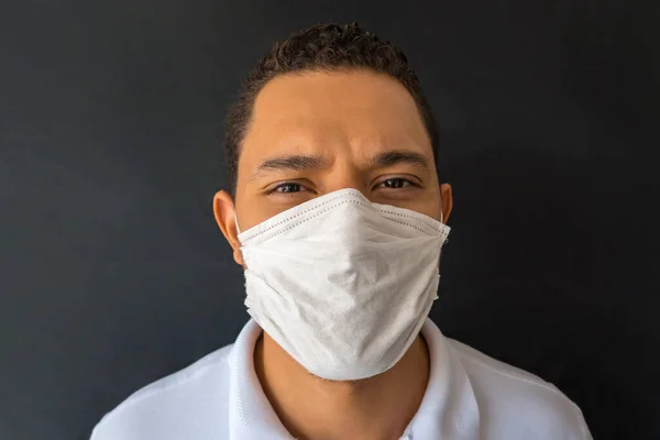 Tıbbi maske takmış bir adamın portresi kameraya bakıyor. Çocuk, Covid19 'un kapanması sırasında evde kalmaya zorlandı. Sosyal uzaklık.