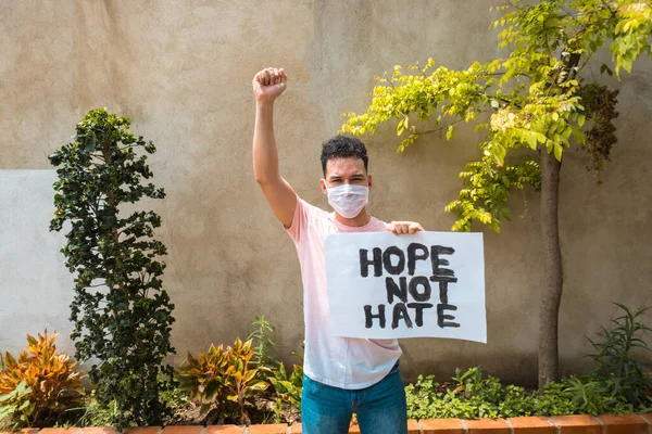 Young man at a protest holding a poster with free space for copies. Concept of protest