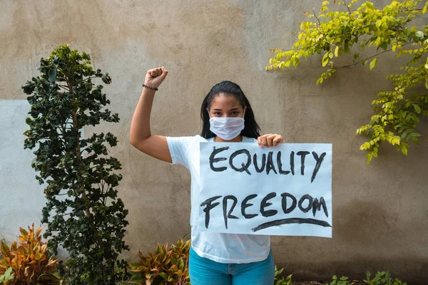 African-American woman protesting holding sign