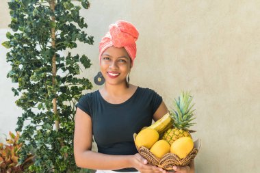 Elinde meyve sepeti olan siyah bir kadın..