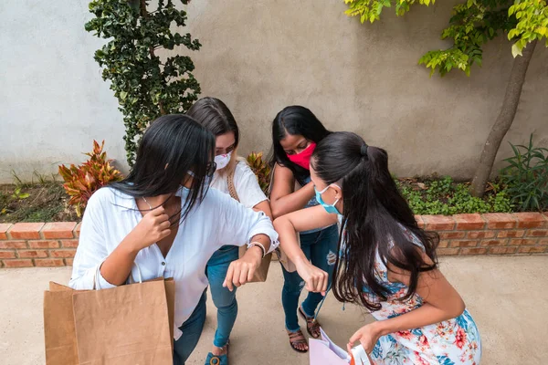 Four people are bumping elbows to avoid the coronavirus on the outside. Friends demonstrating a new form of greeting during the coronavirus epidemic. Concept of health care. Social distancing.