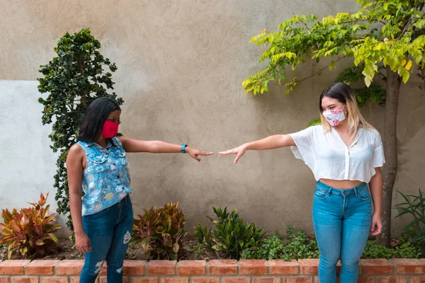 Two women following the rules of social distancing in practice during the pandemic