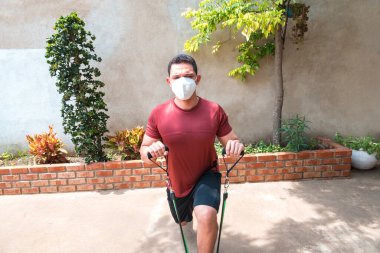 Bir adam covid 19 salgını sırasında maskeyle egzersiz yapıyor..