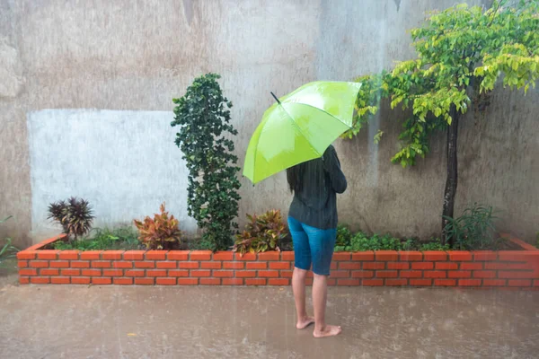 雨の中一人で水の中の公園に傘を差した女の子 — ストック写真