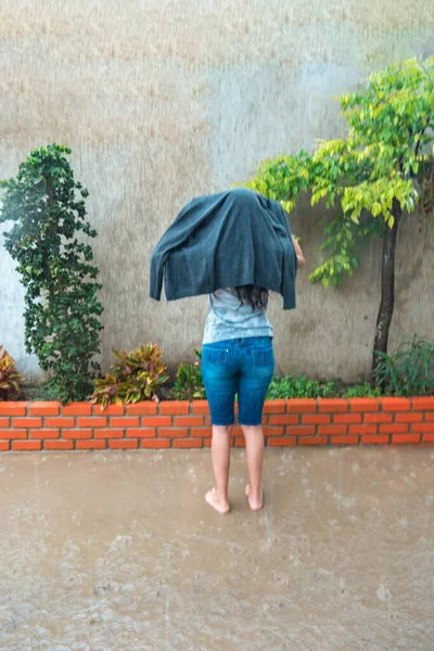 水の真ん中の公園に立っているジャケットの女の子 雨の中で一人で — ストック写真