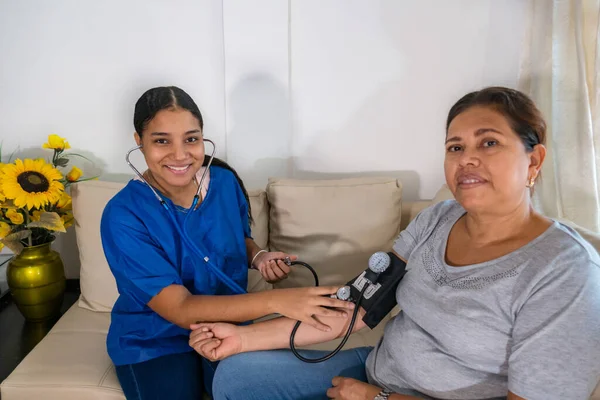 Doktor, muayenehanedeki olgun bir kadına kan basıncını ölçüyor..