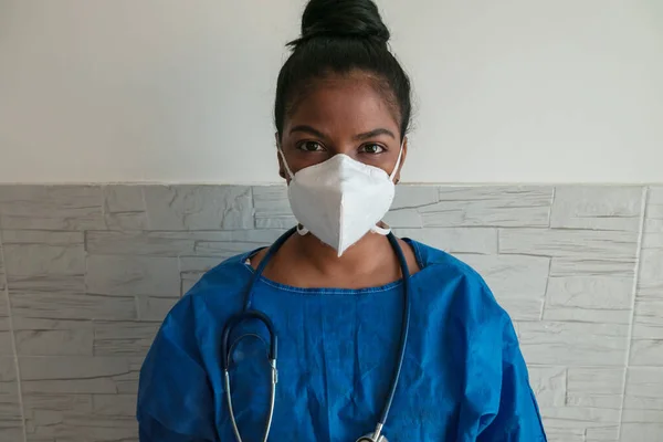 一名年轻的非裔美国护士穿着蓝色制服 戴着面具 躺在医院里 — 图库照片