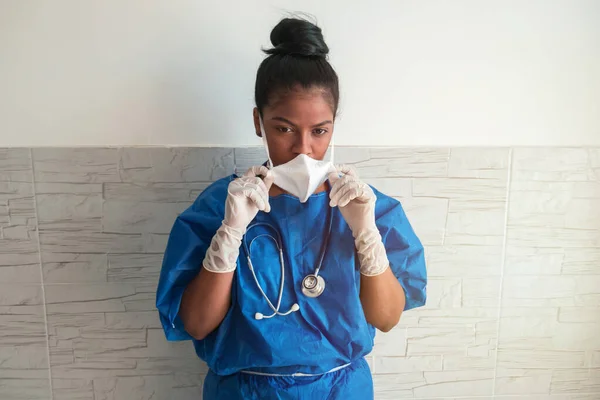 一位穿着手套和蓝色制服的疲惫的非洲裔美国手术室护士摘下她的面具 在医院里呼吸 戴口罩的护士 — 图库照片