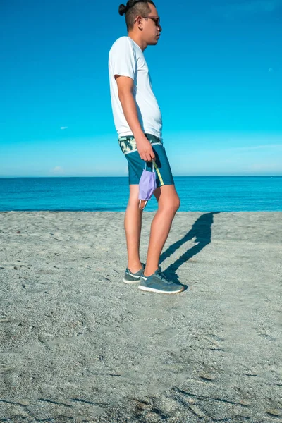 Chodzący Mężczyzna Nosi Niebieskie Kapcie Zielone Szorty Tropikalnej Plaży Trzymając — Zdjęcie stockowe