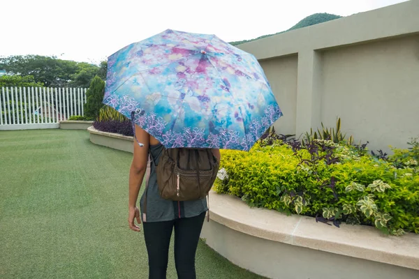 公園の下にマスクと傘を持つアスレチック女性 — ストック写真