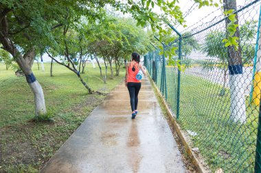 Parkta sırtüstü yürüyen bir kadın