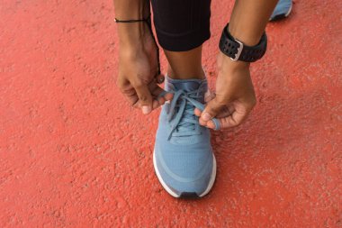 Koşmadan önce ayakkabı bağcıklarını bağlayan kadın koşucu. Spor fitness, koşu egzersizi ve yaşam tarzı konsepti.