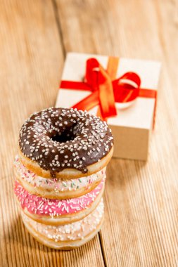 Ahşap arka plan üzerinde mevcut bir kutu ile çörek