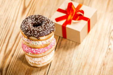 Ahşap arka plan üzerinde mevcut bir kutu ile çörek