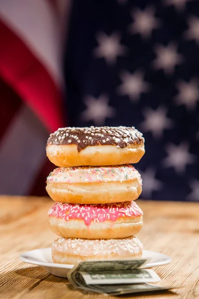 Stos Pączki Pieniądze Stole Tle Flagi Amerykańskiej — Zdjęcie stockowe