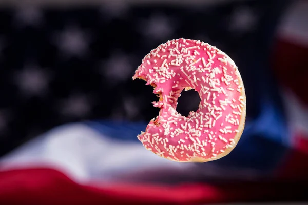 Funny sprinkled donut, bitten donut over americal flag