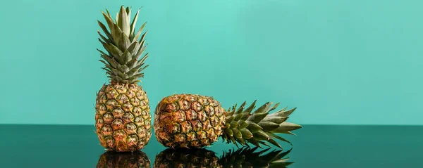 Fresh pineapples on green blue background. Holiday, vacation, healthy food and party mood concept