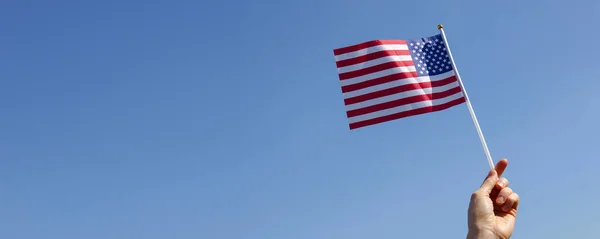 Boy Mão Segurando Bandeira Americana Contra Céu Azul — Fotografia de Stock