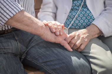 Yaşlı çift dışarıda el ele tutuşuyor. Büyükler