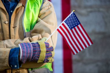 Ciddi bir işçi adam ve Amerikan bayrağı. Vatansever inşaat işçisi