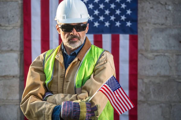 A serious worker man and american flag