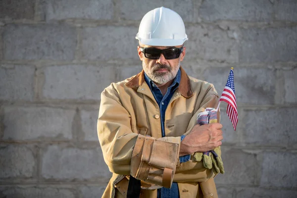 一个严肃的工人和美国国旗 — 图库照片