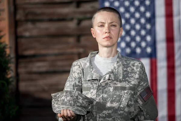 美丽的美国士兵站在美国国旗前 免版税图库照片