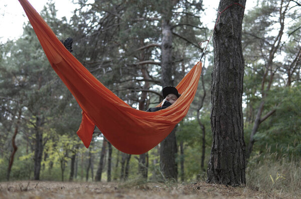 Женщина турист Отдых в Hammock в красивом осеннем лесу. Просто спит.
