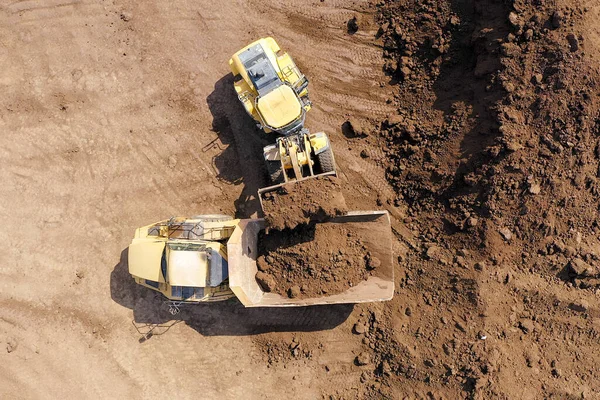 Excavadora cargando tierra sobre un camión de transporte articulado — Foto de Stock