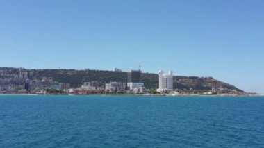 Haifa, Israel - June 14, 2020: Haifa Bay and rumba hospital campus, Aerial towards the coastline, passing above Windsurfers.
