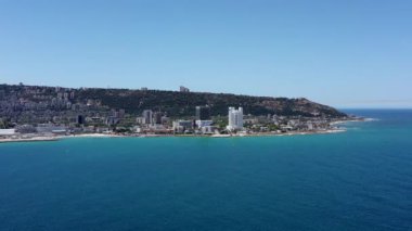 Haifa, Israel - June 14, 2020: Haifa Bay and rumba hospital campus, Aerial towards the coastline, passing above Windsurfers.