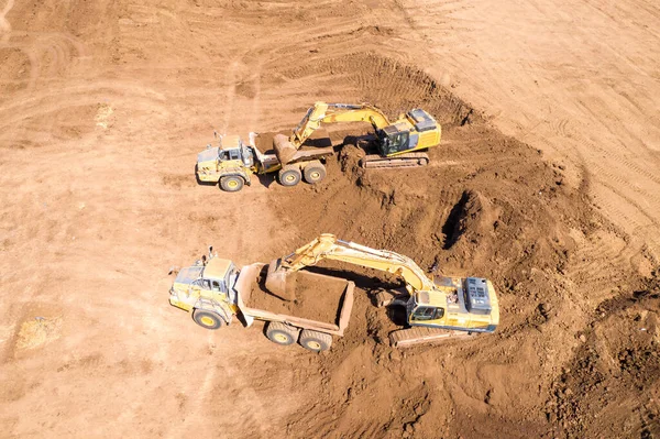 掘削機は、特定の運搬トラックに土壌をロードします — ストック写真