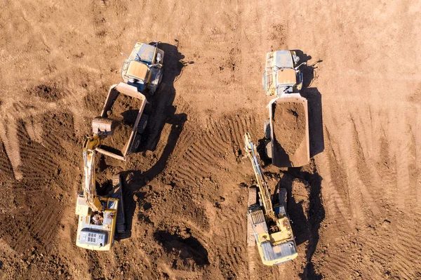 掘削機は、特定の運搬トラックに土壌をロードします — ストック写真