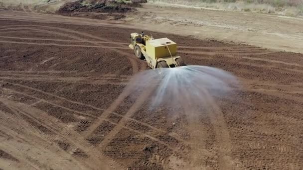 Sattelschlepper versprüht Wasser auf einer großen Ausgrabungsstätte. — Stockvideo