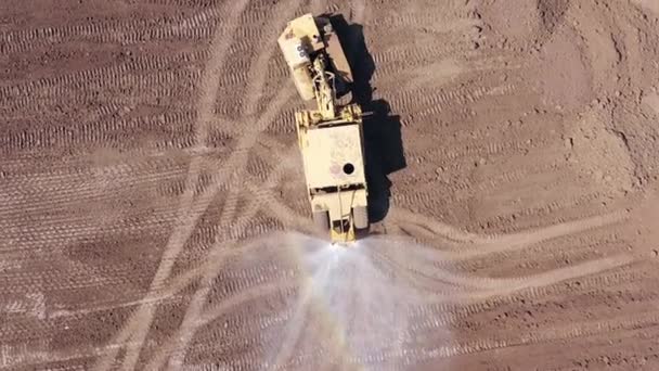 Leddvann fra lastebiler som sprøyter vann på et stort utgravingssted. – stockvideo