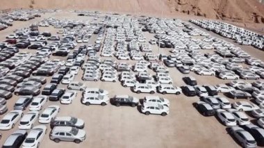 Bekleme platformunda park etmiş koruyucu beyaz çarşaflarla kaplı yeni arabalar..