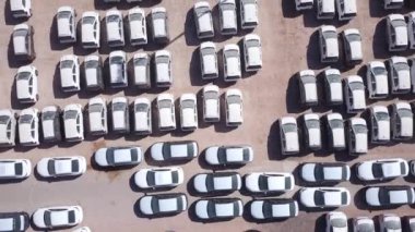 Bekleme platformunda park etmiş koruyucu beyaz çarşaflarla kaplı yeni arabalar..