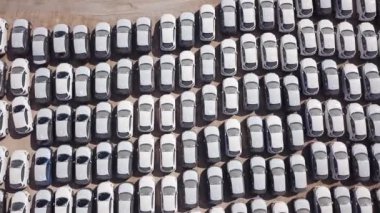 Bekleme platformunda park etmiş koruyucu beyaz çarşaflarla kaplı yeni arabalar..