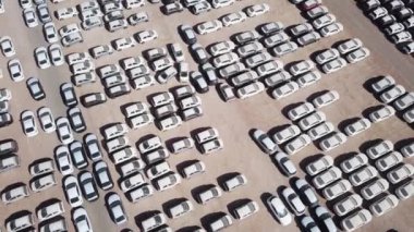 Bekleme platformunda park etmiş koruyucu beyaz çarşaflarla kaplı yeni arabalar..