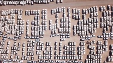Bekleme platformunda park etmiş koruyucu beyaz çarşaflarla kaplı yeni arabalar..