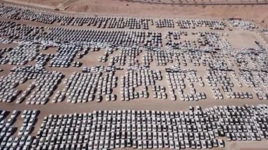 Bekleme platformunda park etmiş koruyucu beyaz çarşaflarla kaplı yeni arabalar..