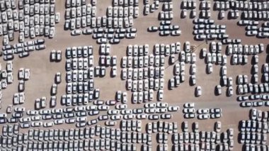 Bekleme platformunda park etmiş koruyucu beyaz çarşaflarla kaplı yeni arabalar..